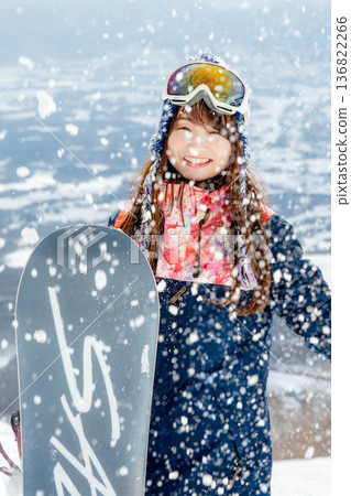 Young woman enjoying snowboarding at the top of the slope Young woman enjoying snowboarding at the top of the slope 136822266