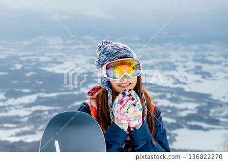 年輕女子在山坡頂端享受滑雪的樂趣 年輕女子在山坡頂端享受滑雪的樂趣 136822270