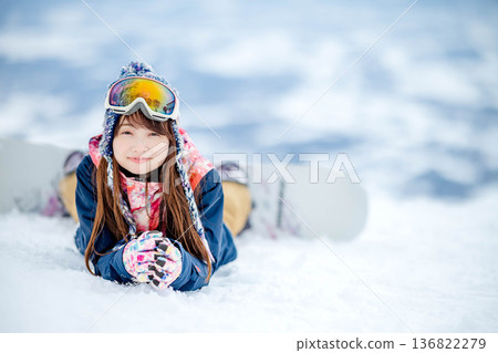 Young woman enjoying snowboarding at the top of the slope Young woman enjoying snowboarding at the top of the slope 136822279