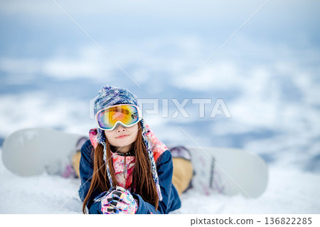 Young woman enjoying snowboarding at the top of the slope Young woman enjoying snowboarding at the top of the slope 136822285
