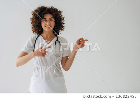 Showing to the copy space. Beautiful woman is in the studio Showing to the copy space. Beautiful woman is in the studio 136822455