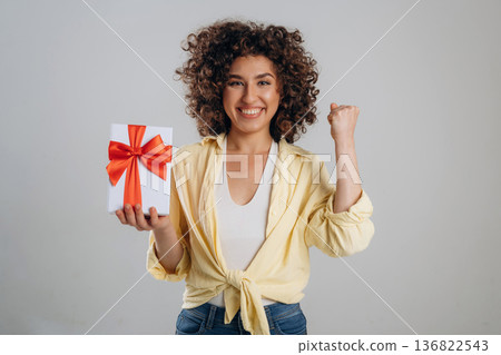 Holidays or birthday conception with gift box. Beautiful woman is in the studio Holidays or birthday conception with gift box. Beautiful woman is in the studio 136822543