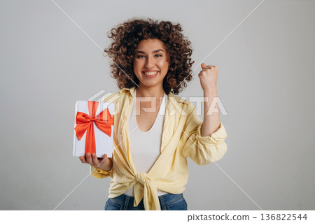 Holidays or birthday conception with gift box. Beautiful woman is in the studio Holidays or birthday conception with gift box. Beautiful woman is in the studio 136822544