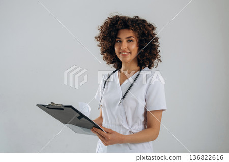 Stethoscope is on the neck. Beautiful doctor woman is in the studio Stethoscope is on the neck. Beautiful doctor woman is in the studio 136822616