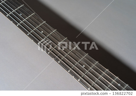Close-up of a dark wooden guitar fretboard neck 136822702