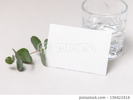 Mockup of blank card near green eucalyptus branche sand crystal glasses. Presentation template Mockup of blank card near green eucalyptus branche sand crystal glasses. Presentation template 136822818