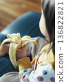 A 2-year-old child eating a banana for breakfast. Family image material for parenting and nutrition presentations and slideshows. 136822821