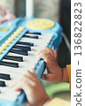 A close-up of a child playing a toy piano. Musical image background material suitable for educational presentations and slideshows. 136822823