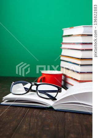 World Book and Copyright Day education concept with stacked books, reading glasses, red coffee cup. Intellectual work, publishing culture, protected knowledge 136822883