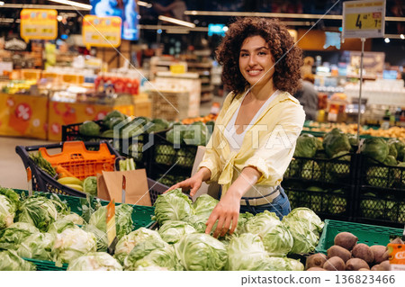 Cabbage is in hands. Gorgeous woman is in the grocery store Cabbage is in hands. Gorgeous woman is in the grocery store 136823466