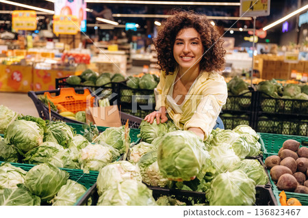 Cabbage is in hands. Gorgeous woman is in the grocery store Cabbage is in hands. Gorgeous woman is in the grocery store 136823467