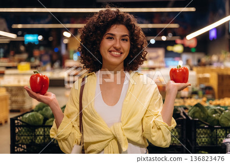 Healthy eating concept, with pepper. Gorgeous woman is in the grocery store Healthy eating concept, with pepper. Gorgeous woman is in the grocery store 136823476