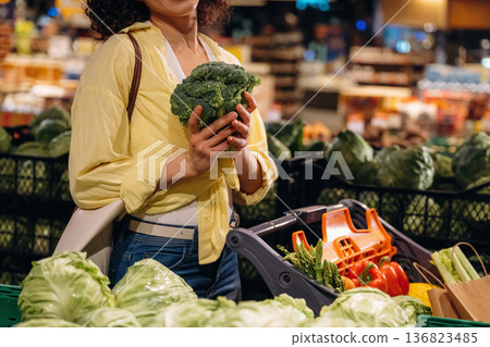 Close up view of woman that is choosing vegetables in the grocery store, supermarket Close up view of woman that is choosing vegetables in the grocery store, supermarket 136823485