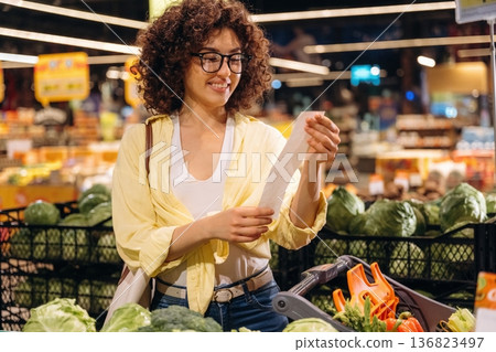 Reading the check. Gorgeous woman is in the grocery store Reading the check. Gorgeous woman is in the grocery store 136823497