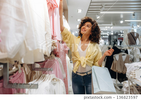 Brand new wear. Woman is shopping in the clothing store Brand new wear. Woman is shopping in the clothing store 136823597