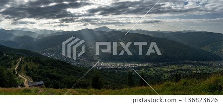 Mountain Valley with Sun Rays Breaking Through Clouds 136823626