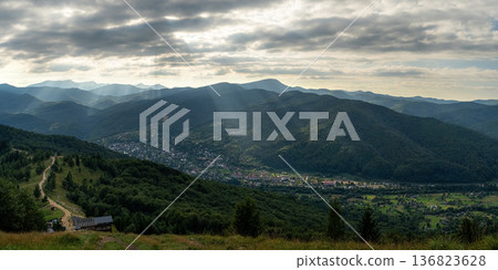 Mountain Valley with Sun Rays Breaking Through Clouds 136823628