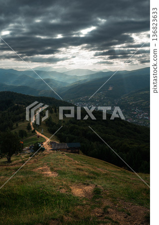Dramatic Mountain Valley with Winding Road and Sun Rays 136823633