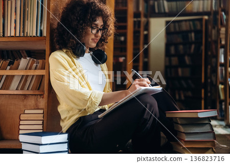 Beautiful woman is in the library 136823716