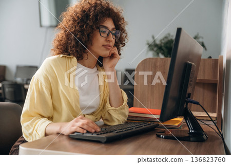 Woman is in the library section with computers 136823760
