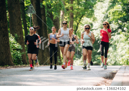 Adults are running together. Group of people are outdoors Adults are running together. Group of people are outdoors 136824102