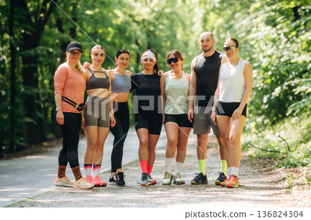 Posing, looking forward. Group of runners are together outdoors Posing, looking forward. Group of runners are together outdoors 136824304