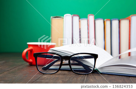 World Book and Copyright Day education concept with stacked books, reading glasses, red coffee cup. Intellectual work, publishing culture, protected knowledge 136824353