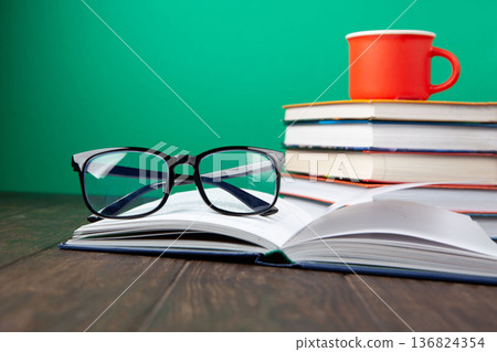 World Book and Copyright Day education concept with stacked books, reading glasses, red coffee cup. Intellectual work, publishing culture, protected knowledge 136824354