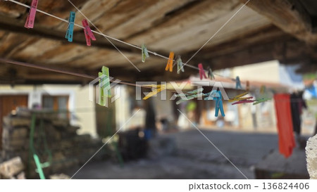 Colorful clothespins on a clothesline in rustic outdoor setting 136824406