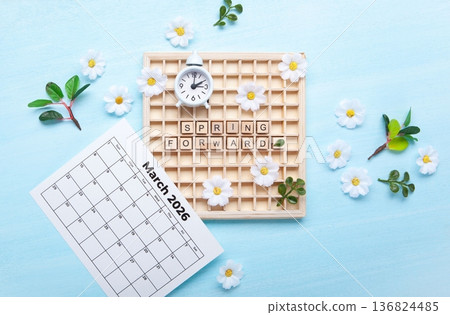 Daylight saving Time, Spring forward, Summer back concept. White Alarm Clock and Spring Daisy Flowers on Blue Background 136824485