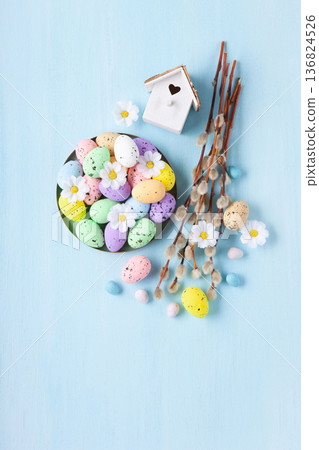 Easter spring holiday card. Playful bunny, painted eggs, willow branches, spring flowers, decorative elements on light blue background Easter spring holiday card. Playful bunny, painted eggs, willow branches, spring flowers, decorative elements on light blue background 136824526