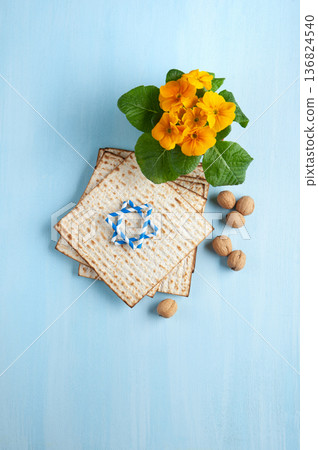 Passover holiday card with matzah, walnuts, yellow spring flowers on light blue background, gold and white accents, copy space Passover holiday card with matzah, walnuts, yellow spring flowers on light blue background, gold and white accents, copy space 136824540