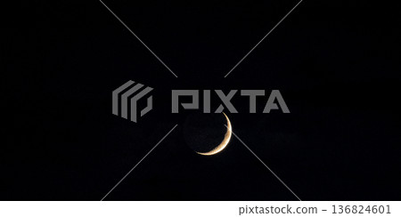Crescent moon floating in the night sky 136824601