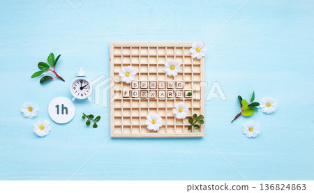 Daylight saving Time, Spring forward, Summer back concept. White Alarm Clock and Spring Daisy Flowers on Blue Background 136824863