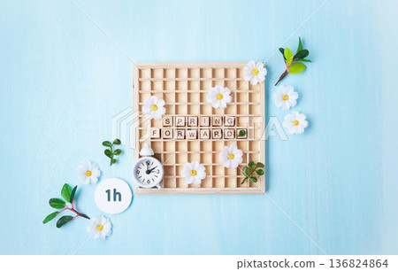 Daylight saving Time, Spring forward, Summer back concept. White Alarm Clock and Spring Daisy Flowers on Blue Background 136824864