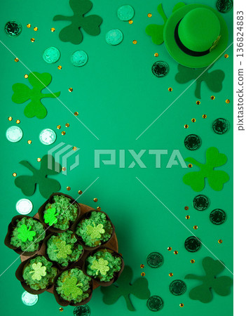 St. Patrick's Day vanilla cupcakes with green frosting and shiny clover decorations on green background. Irish holiday dessert concept. Top view, copy space St. Patrick's Day vanilla cupcakes with green frosting and shiny clover decorations on green background. Irish holiday dessert concept. Top view, copy space 136824883