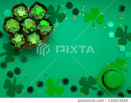 St. Patrick's Day vanilla cupcakes with green frosting and clover decorations on green background. Irish holiday dessert concept. Top view, copy space St. Patrick's Day vanilla cupcakes with green frosting and clover decorations on green background. Irish holiday dessert concept. Top view, copy space 136824884