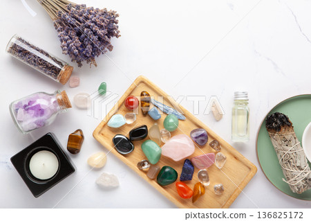 Chakra Crystal Healing Ritual With Lavender Palo Santo White Sage Essential Oils And Candles On White Marble Background 136825172
