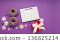 Give to Gain concept for International Women's Day, 8 march. Two purple doughnuts, red gift box and spring flowers, top view flat lay 136825214