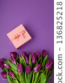 Holiday gift with pink ribbon bow, bouquet of purple tulips flower on purple background.  Happy Mother's Day spring design. 136825218