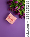 Holiday gift with pink ribbon bow, bouquet of purple tulips flower on purple background.  Happy Mother's Day spring design. 136825219