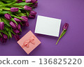 Holiday gift with pink ribbon bow, bouquet of purple tulips flower on purple background.  Happy Mother's Day spring design. 136825220