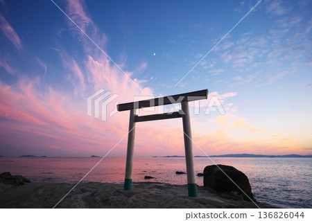 Chita Peninsula in autumn: The Tsubutegaura Torii gate stands against the backdrop of a sunset-colored sky Chita Peninsula in autumn: The Tsubutegaura Torii gate stands against the backdrop of a sunset-colored sky 136826044