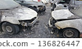 Burned and severely damaged cars parked in a lot after a fire incident. 136826447