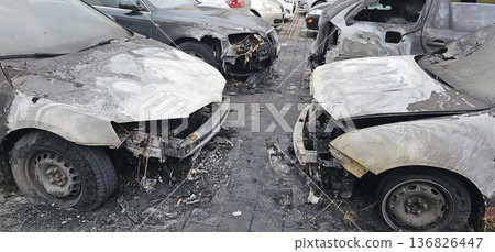 Burned and severely damaged cars parked in a lot after a fire incident. Burned and severely damaged cars parked in a lot after a fire incident. 136826447