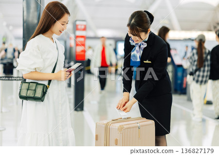 一名機場地勤女工作人員正在為旅客的隨身行李貼標籤。 （圖片由關西國際機場（KIX）提供） 136827179