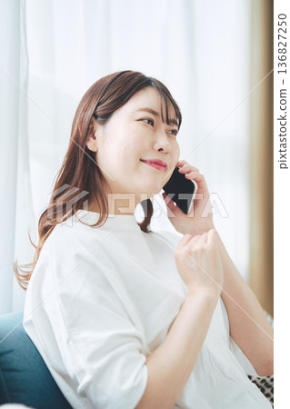 一位30多歲的女性在家中客廳使用智慧型手機的生活方式 136827250