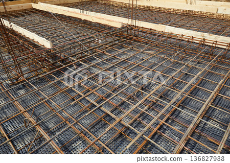 Steel reinforcement is placed in wooden molds and formwork on a construction site  136827988