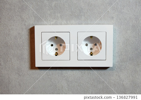Electrical outlets are neatly arranged on a gray wall in a modern interior 136827991