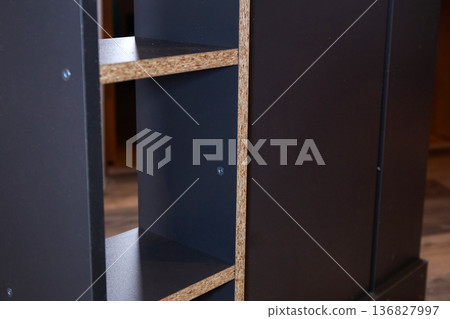 Wooden shelf unit is being assembled in a room with natural light on a weekday in the afternoon Wooden shelf unit is being assembled in a room with natural light on a weekday in the afternoon 136827997